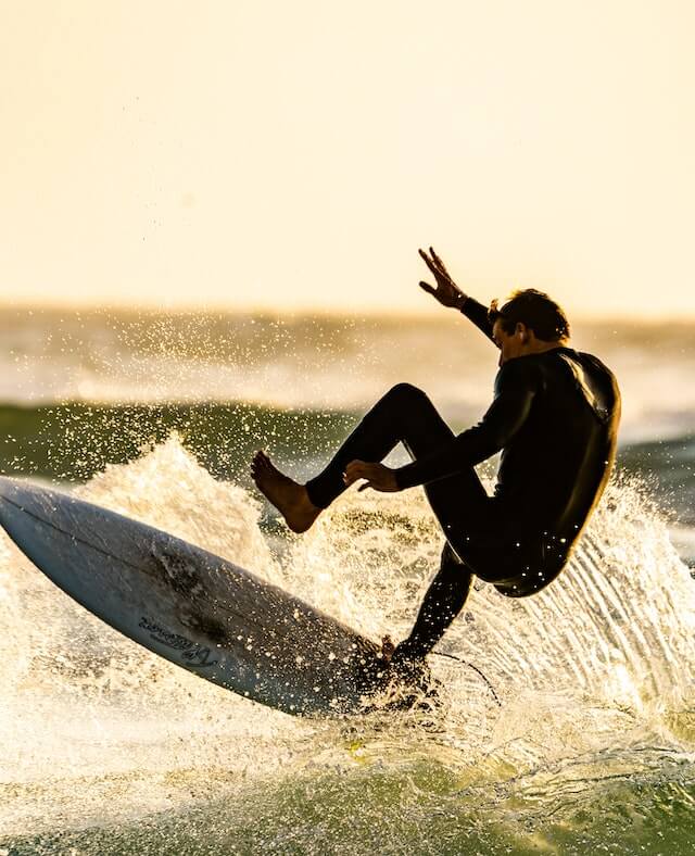A men carring his surfing boat